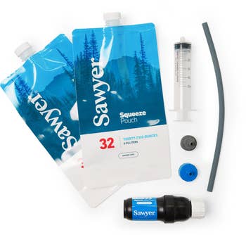 Sawyer Squeeze water filtration system, featuring two squeeze pouches, a filter, syringe, and tubing for safe drinking water while camping