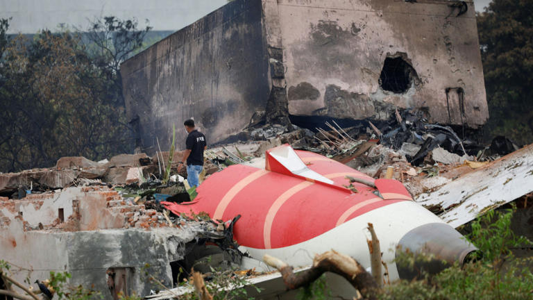 FILE PHOTO: A fire offical stands next to the crashed Air India Boeing 787-8 Dreamliner aircraft, in Ahmedabad, India, June 13, 2025. REUTERS/Adnan Abidi/File Photo