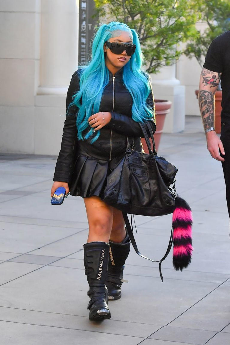 North West rocks an all-leather look, hand piercings and signature blue ...