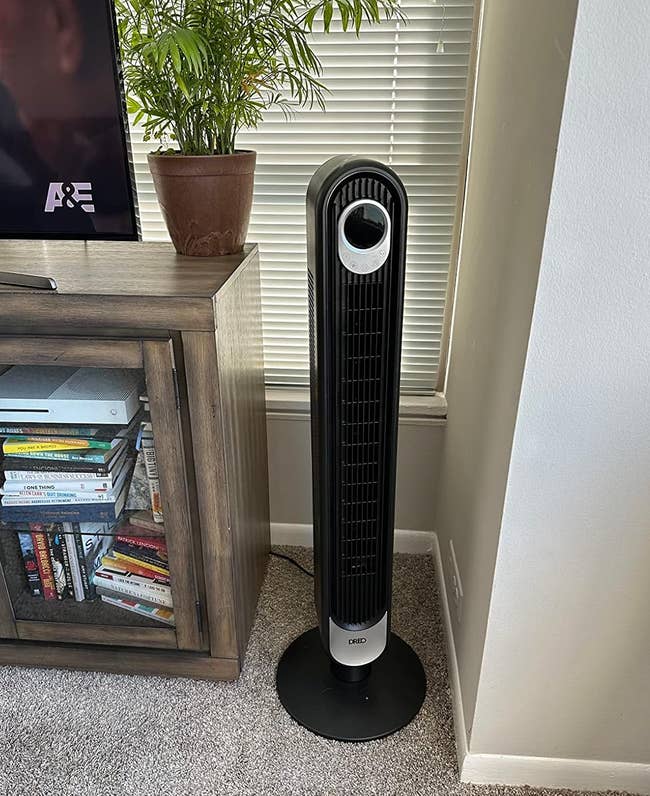 The sleek black Dreo tower fan in a reviewer's living room