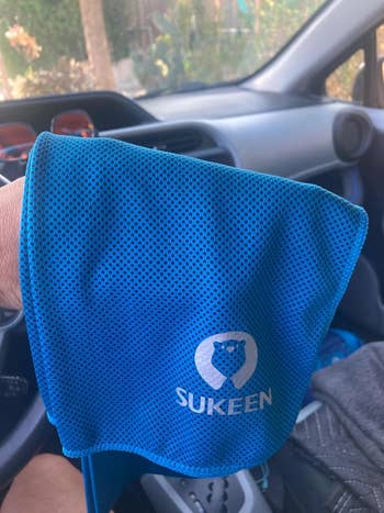 Reviewer holding a blue cooling towel