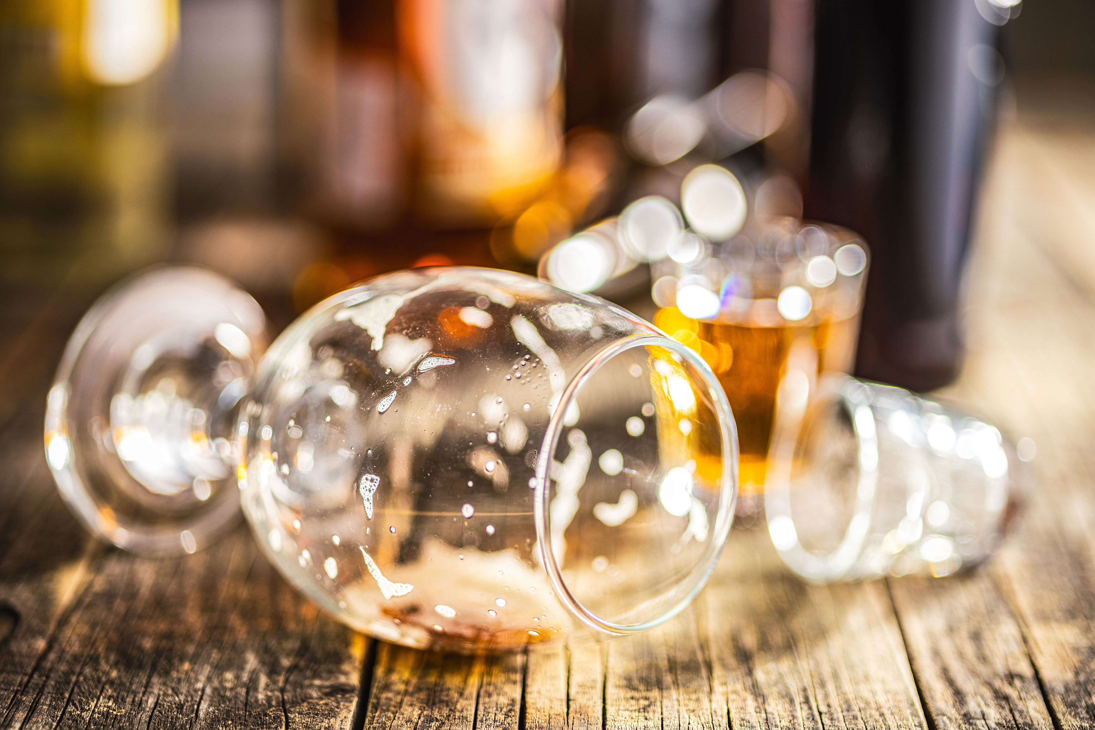 Empty glasses on a bar, a blurred half-filled glass is in the background