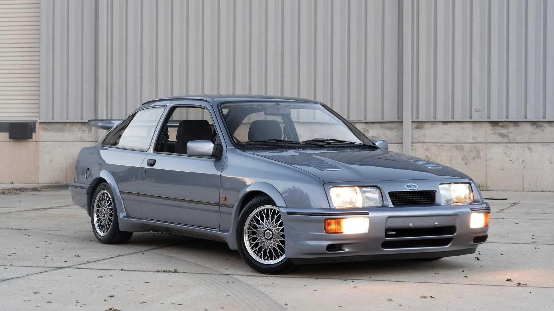 1987 Ford Sierra RS Cosworth Silver Front Angled View Lights On
