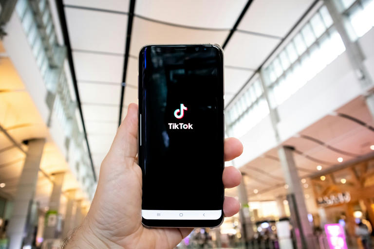 Hand of man holding mobile phone opening Tik Tok application, ©Olivier Bergeron / Unsplash