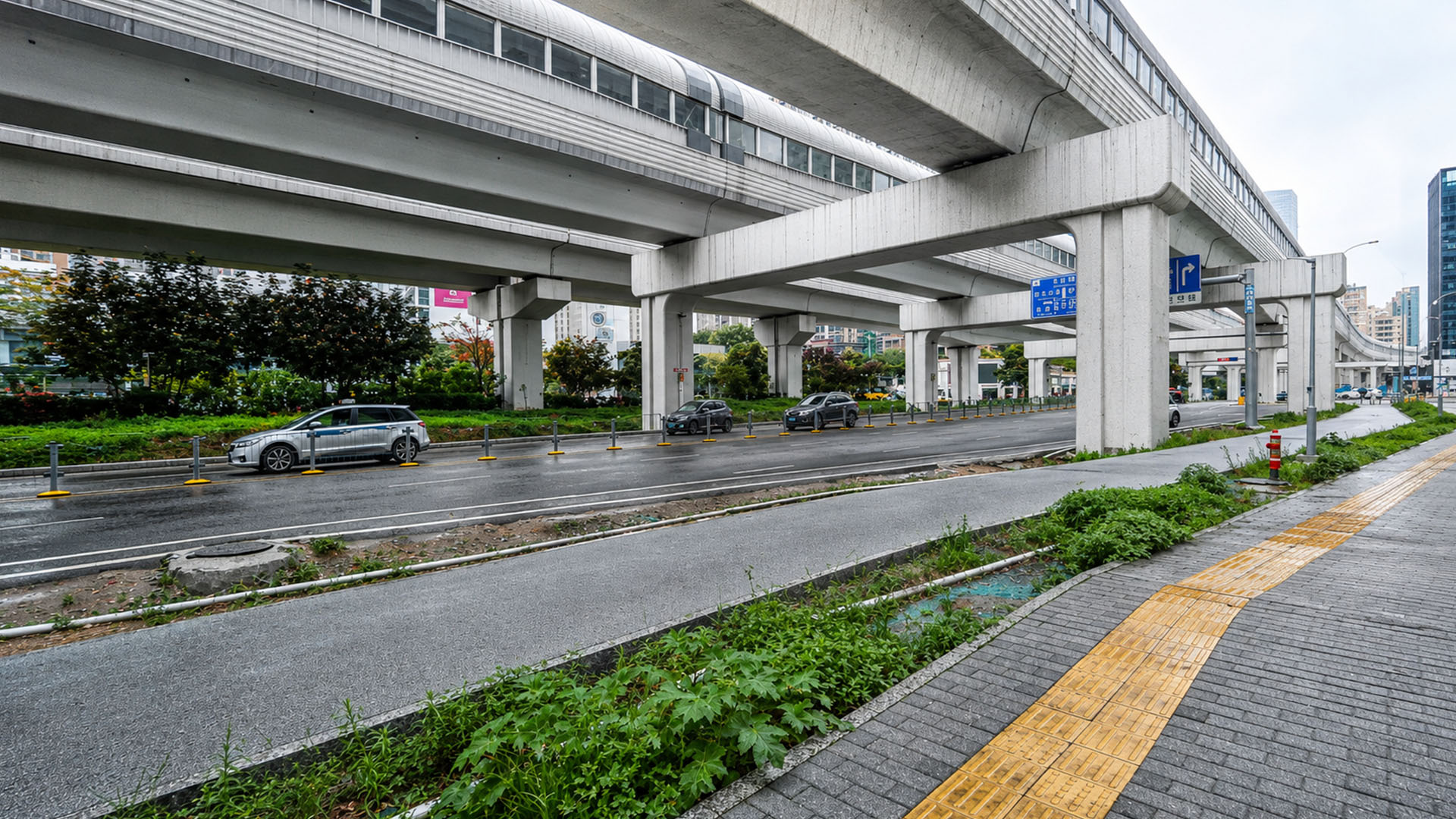 China’s rainy street runs beneath a massive elevated transit line