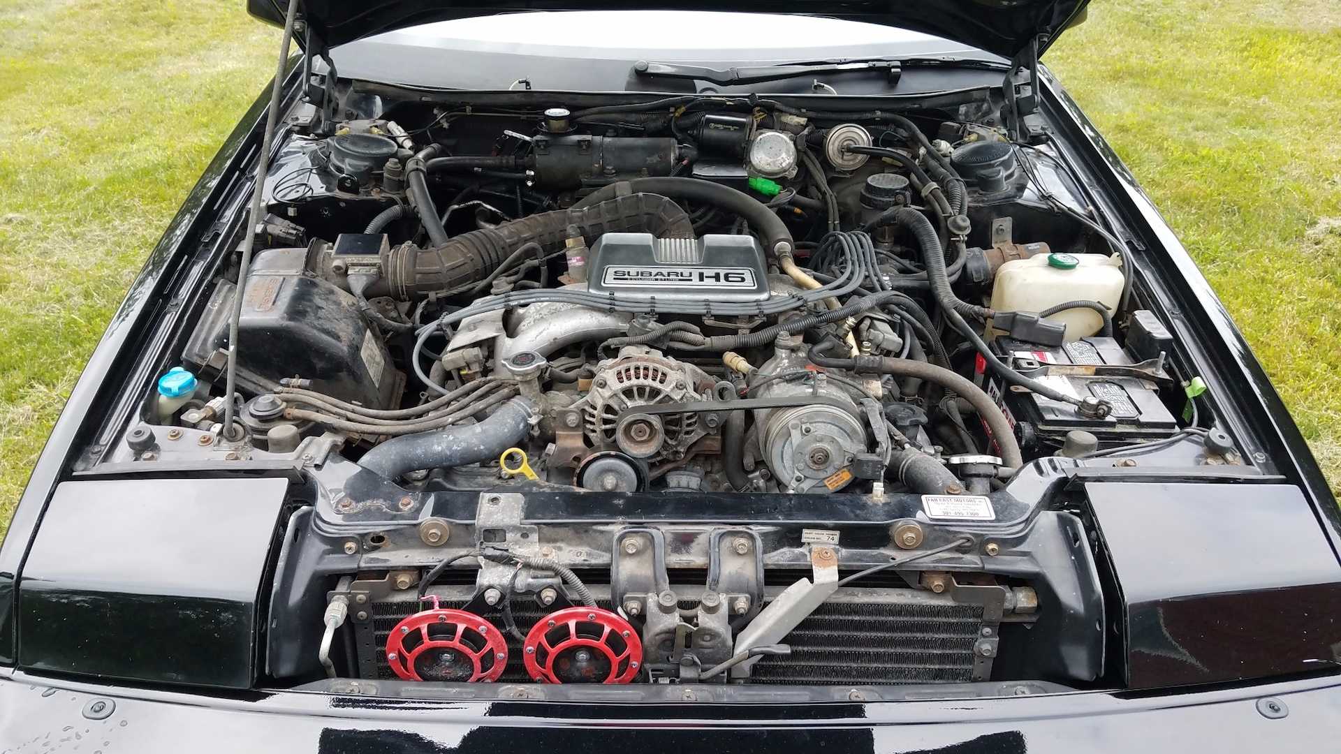 The engine bay of a black 1988 Subaru XT6