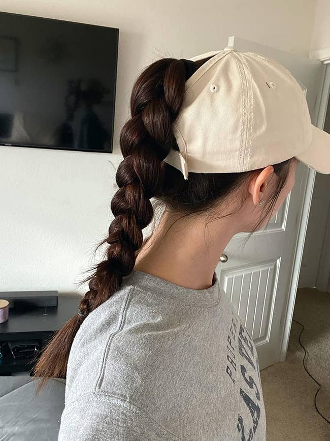 reviewer with long braid wearing a light cap