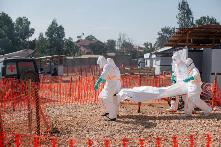 Members of specialised response teams carry to the morgue of the Evangelical Medical Center of Nyankunde (CME) the body of a person who died from Ebola virus disease (AFP/Getty)