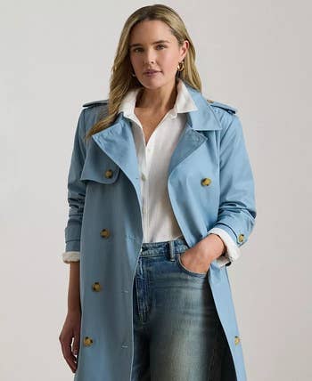 Person wearing a stylish trench coat over a white shirt and jeans, suitable for a casual yet sophisticated shopping look