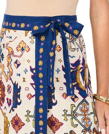 A patterned wrap skirt with a blue tie, featuring intricate geometric and floral designs