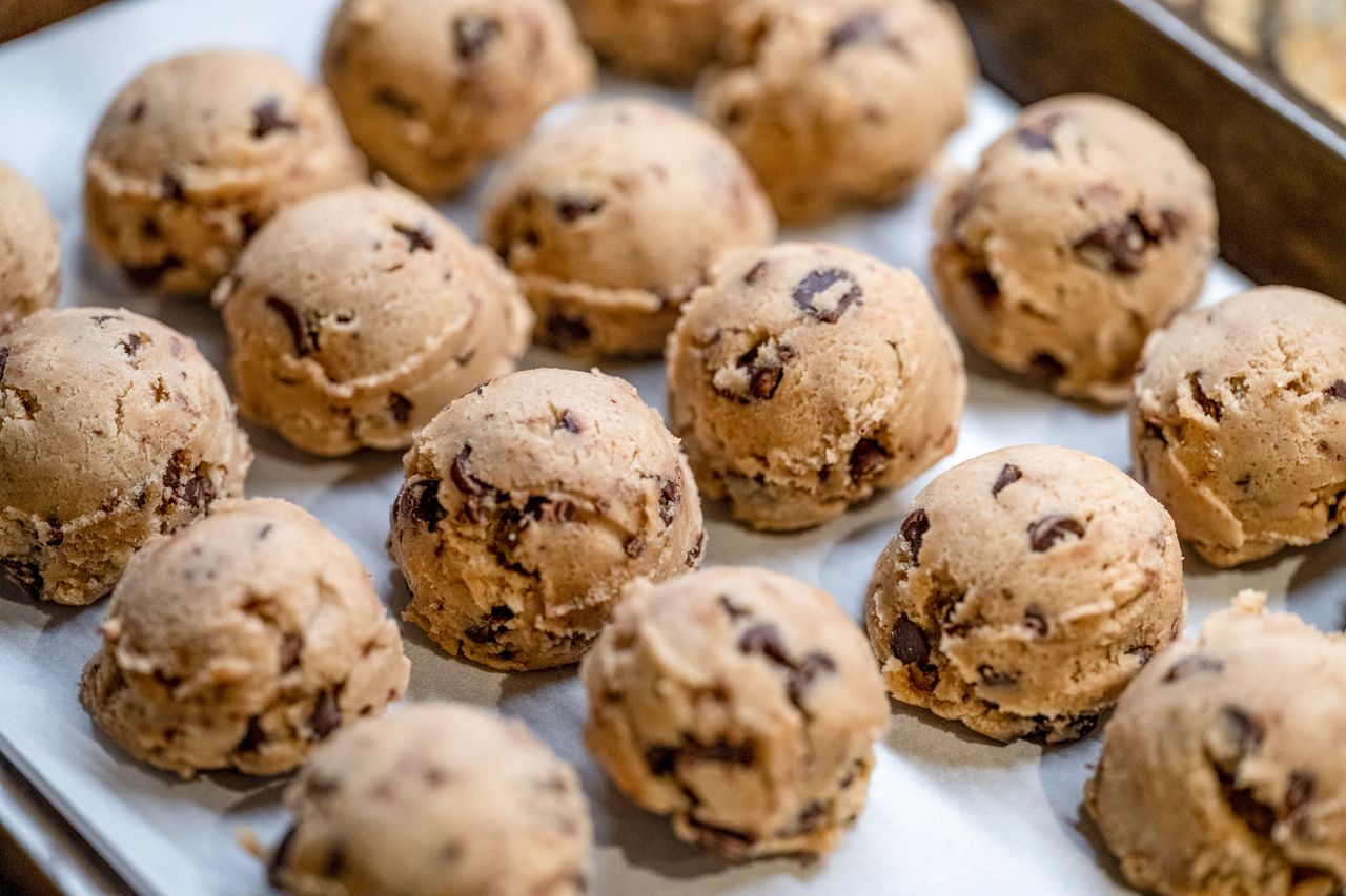 Scoops of chocolate chip cookie dough on a baking sheet