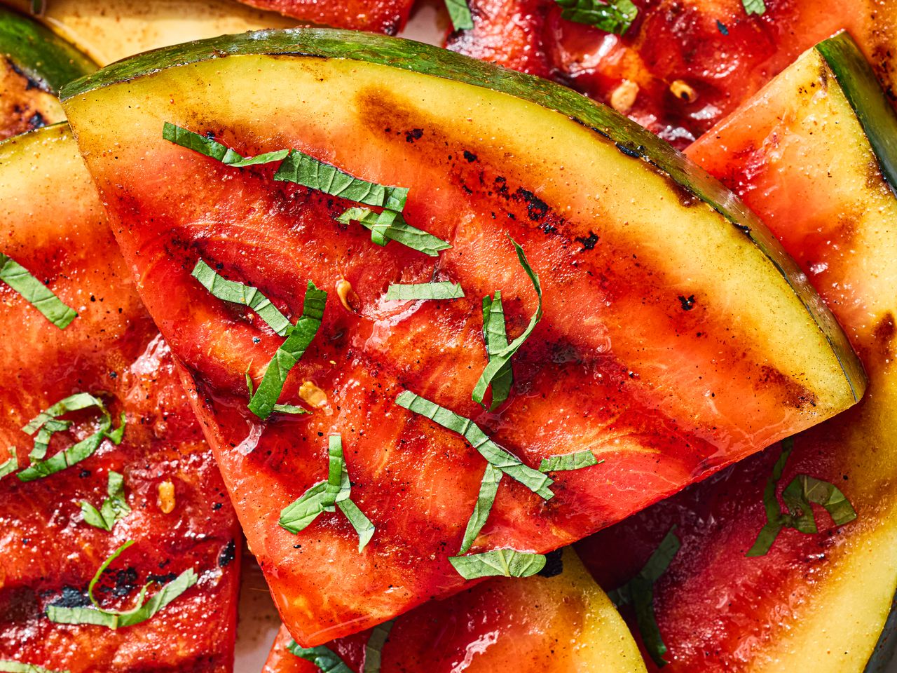 Slices of grilled watermelon garnished with herbs