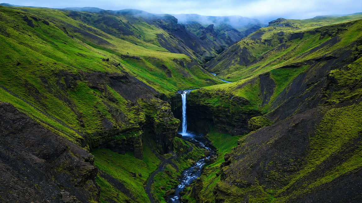 A hidden waterfall lost among endless green hills