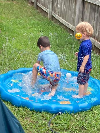 reviewer's two kids playing on the splash pad