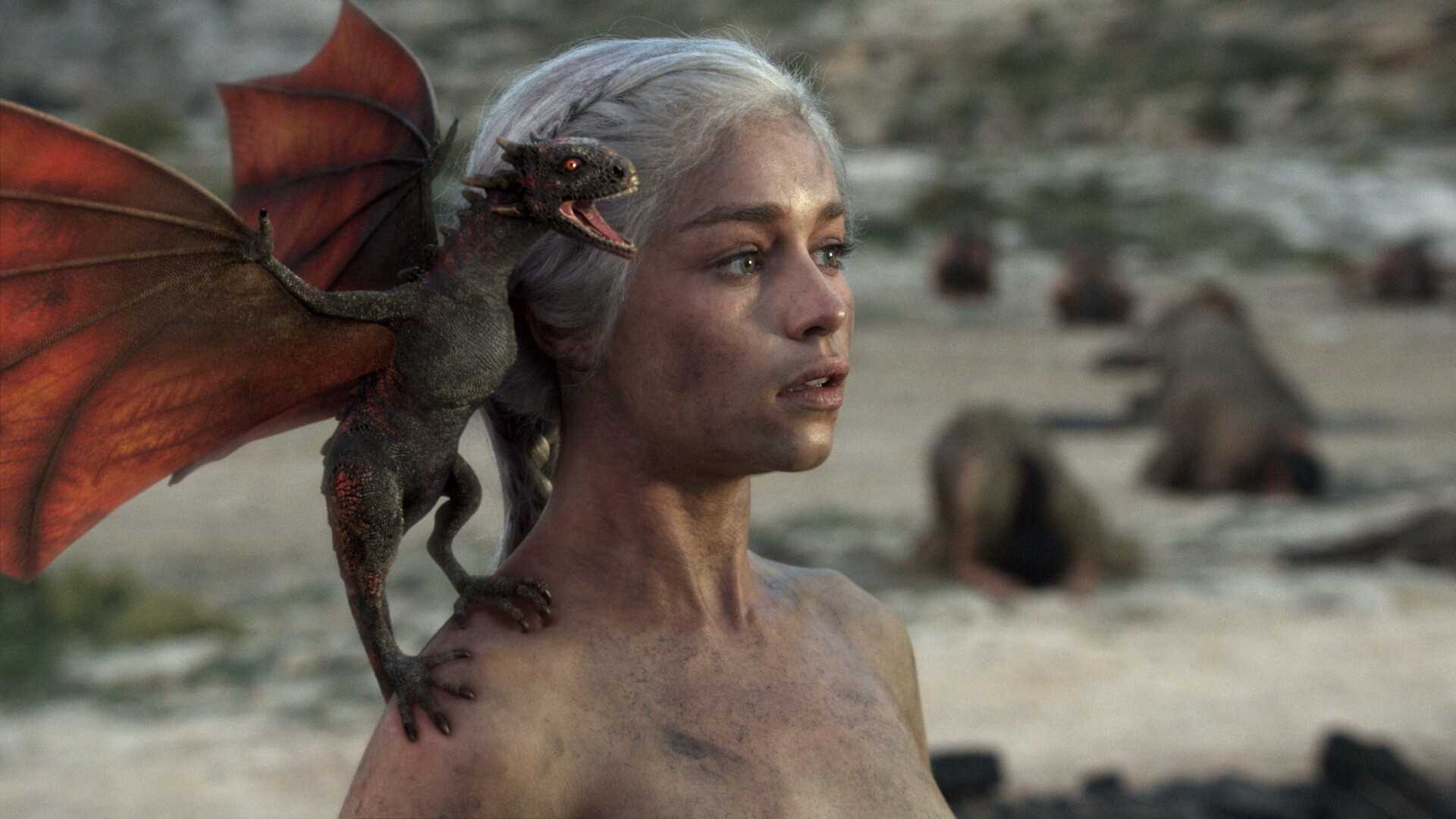 Emilia Clarke as Daenerys Targaryen in Game of Thrones with a dragon on her shoulder