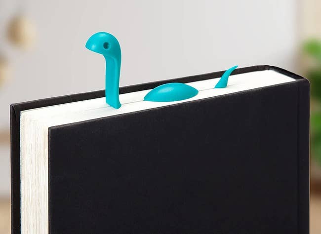 Nessie-shaped bookmark emerges from a book, bringing charm and creativity to reading sessions