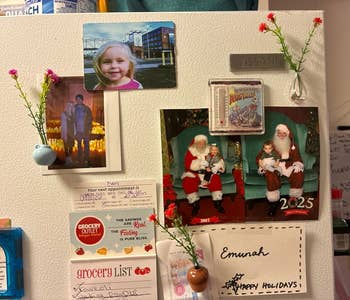 Refrigerator with family photos, holiday card featuring Santa, and grocery list