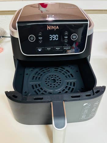 Digital air fryer with an open drawer, showing control panel displaying 390 degrees