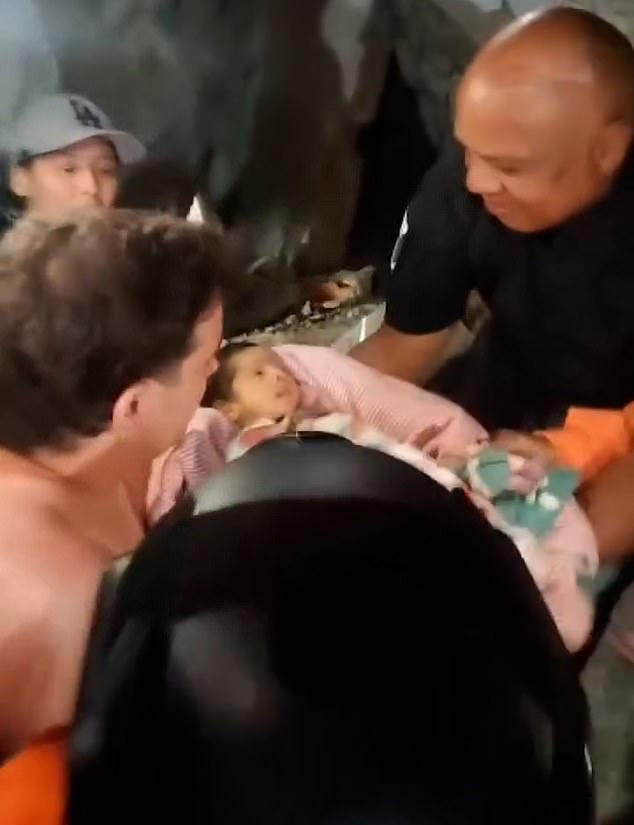 Footage shows the moment rescuers in the city of La Guaira moved the baby away from the debris and handed it over to a man, who appeared to be the father