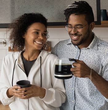 two models, one of whom is holding the coffee-filled mug