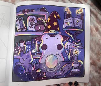 Illustrated scene with a cute wizard frog, crystal ball, potion bottles, a cat, and an open spell book in a whimsical, magical setting