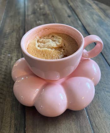 pink cup on saucer with coffee in it