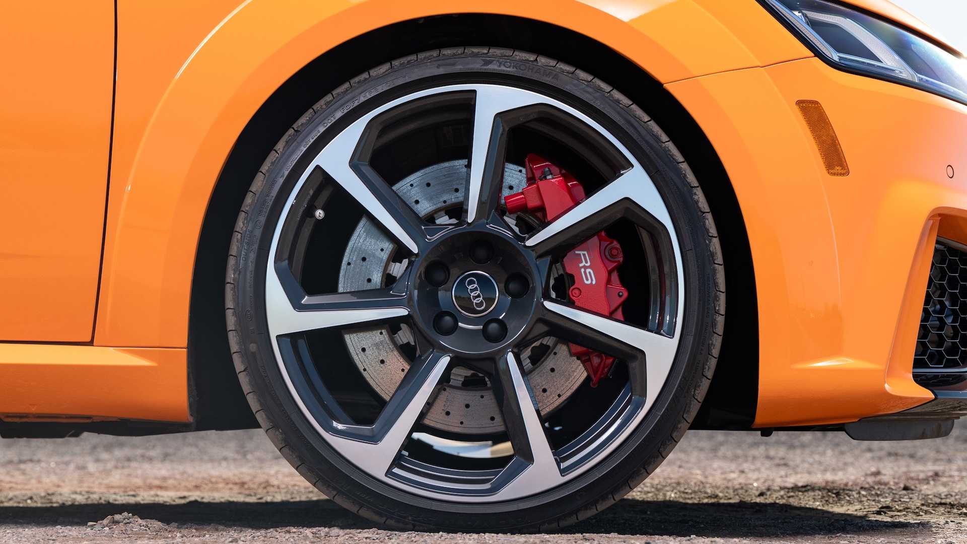 Closeup of the wheels and brakes in an orange audi sports car