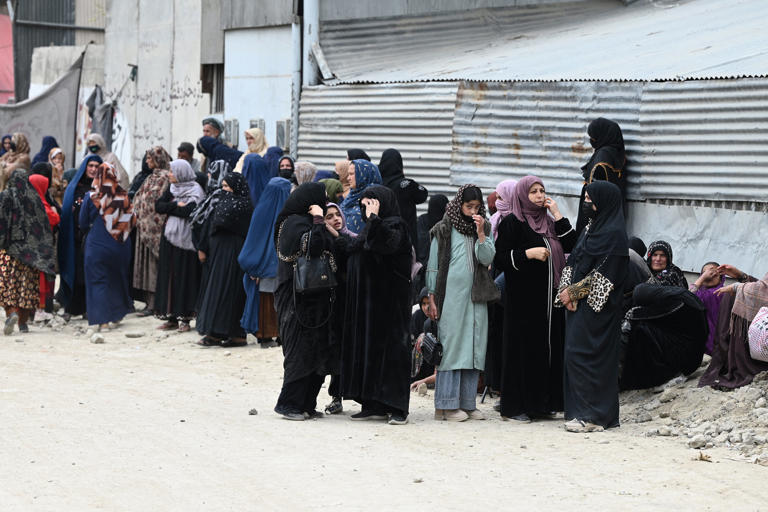 Afghans wait outside to seek news of their relatives at the site after Pakistani airstrikes hit the Omid Addiction Treatment Hospital in Kabul (AFP/Getty)
