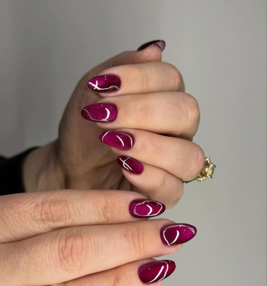 Dark purple cat-eye nails with silver chrome accents