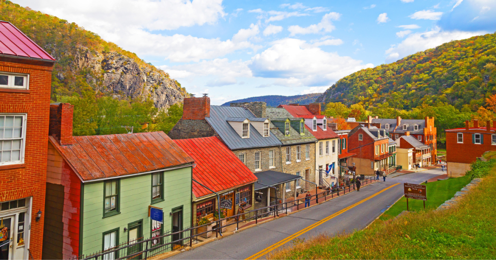Historic Harpers Ferry, with its brick and stone storefronts, surrounded by mountains in the early fall.