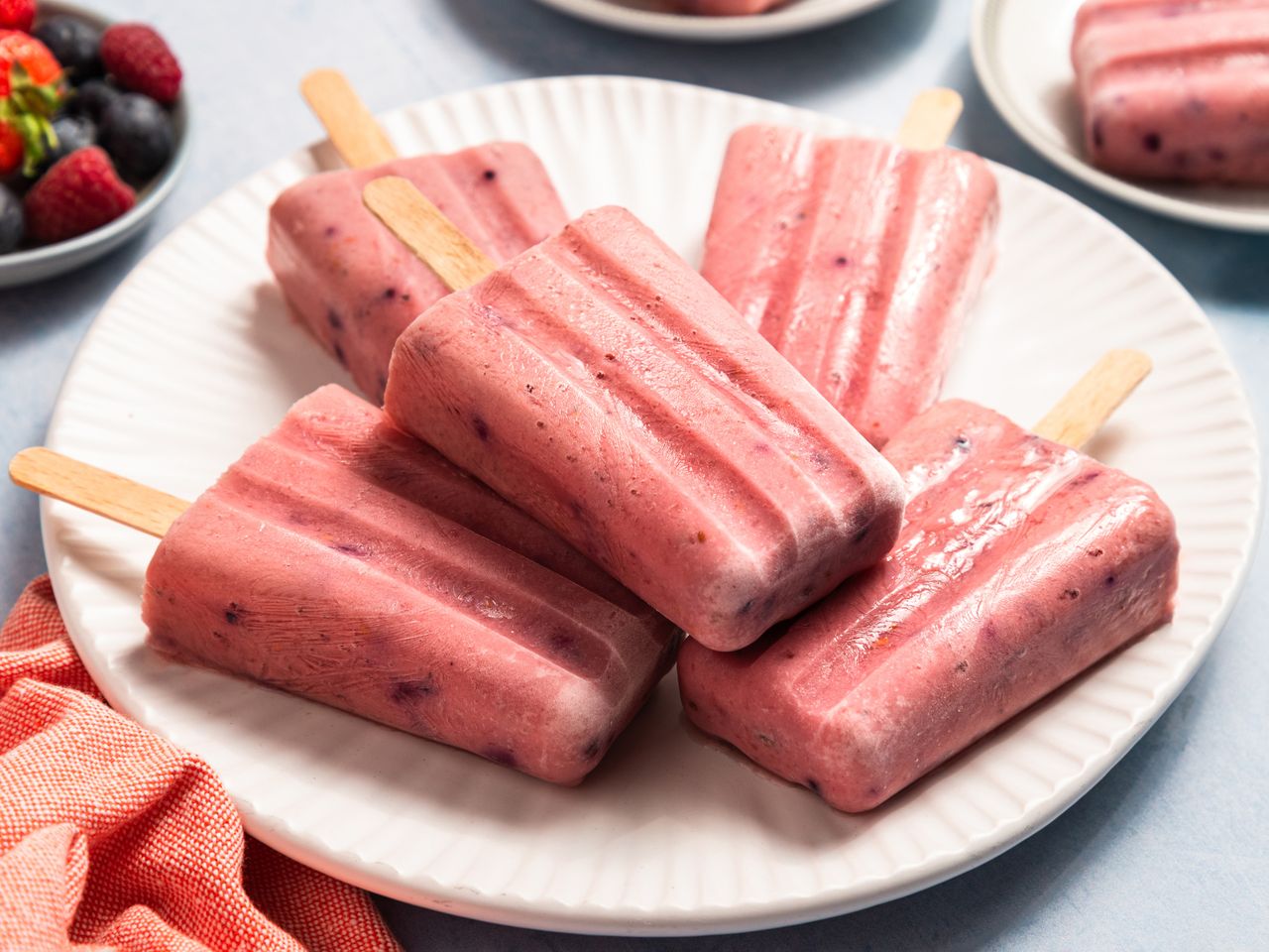 A plate of yogurt and fruit ice pops arranged on a table