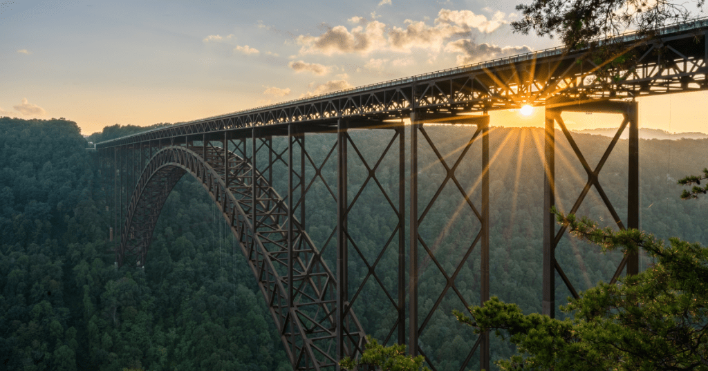 Sun setting over the dramatic canyon at New River Gorge in West Virginia with the famous bridge crossing.