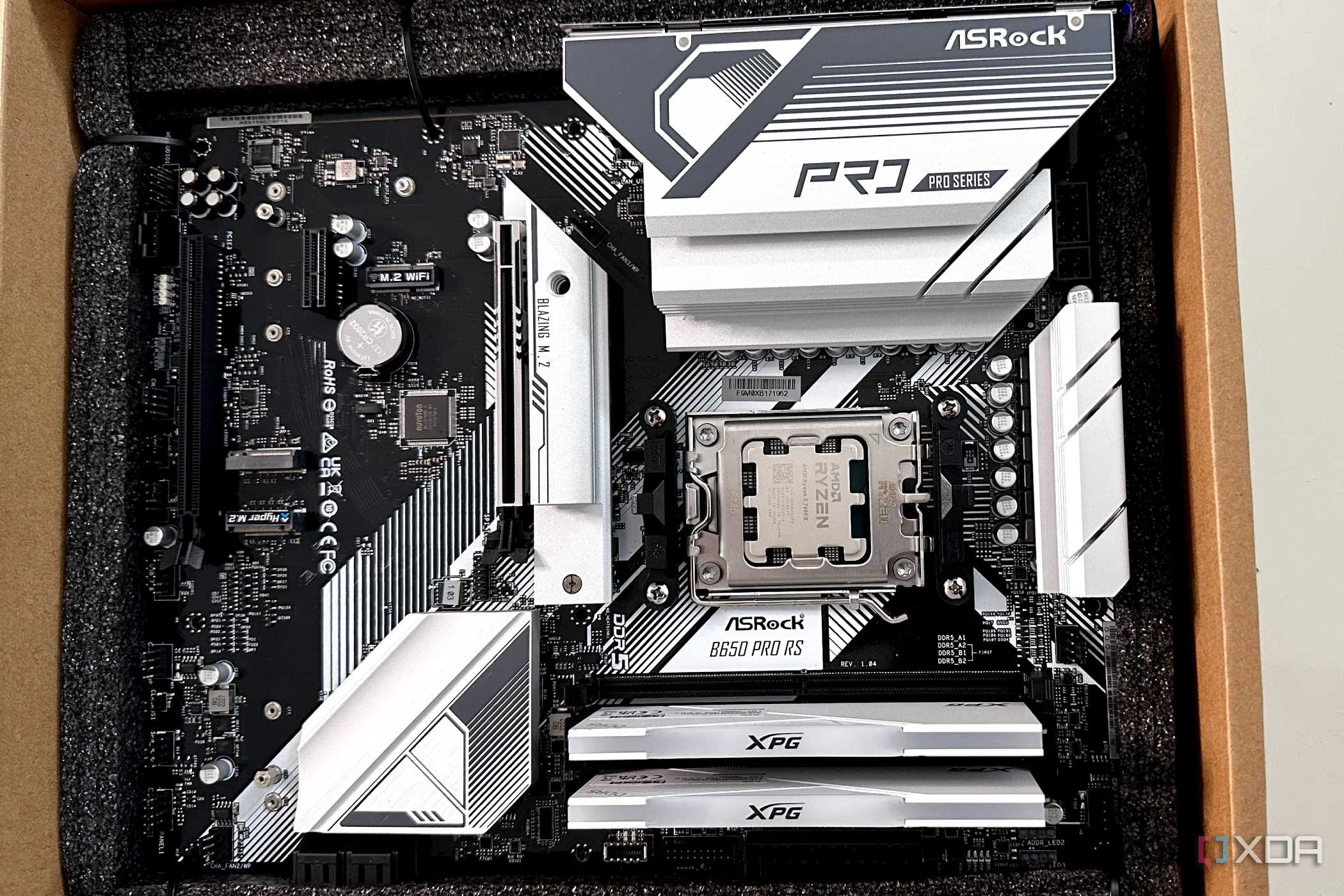 An AsRock B650 Pro RS motherboard in a box with RAM and CPU mounted.