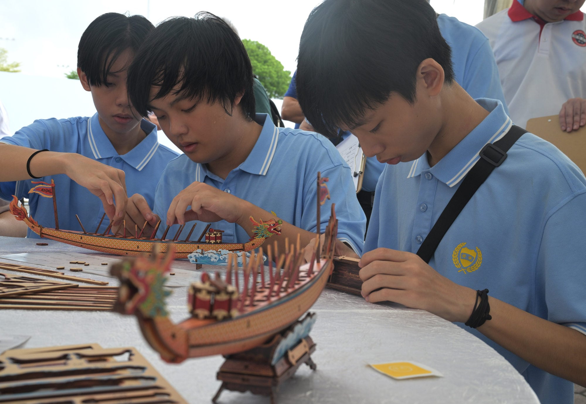 Students assemble dragon boat models in Singapore on June 20. Photo: Xinhua