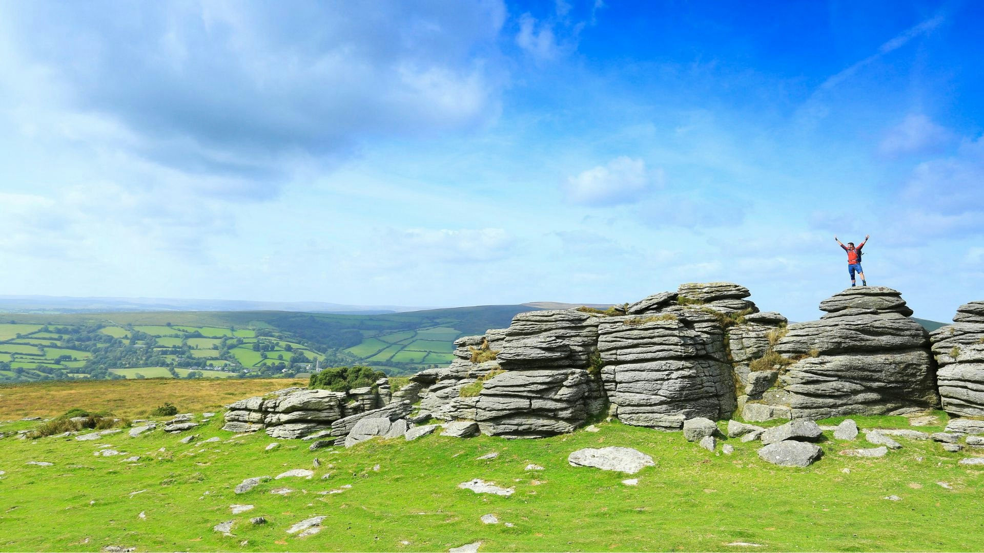 walker standing on some rocks in dartmoor