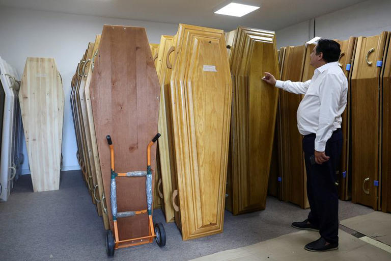An employee at Orly International Funeral Home checks coffins as the facility reaches full capacity amid a heatwave that has caused about 1,000 excess deaths in France, in Orly, France, June 29, 2026. REUTERS/Alice Sacco