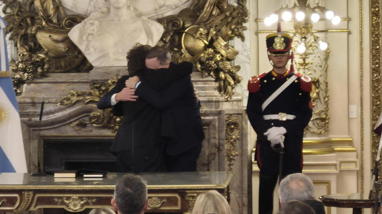 Abrazo entre Milei, Santilli y Adorni.