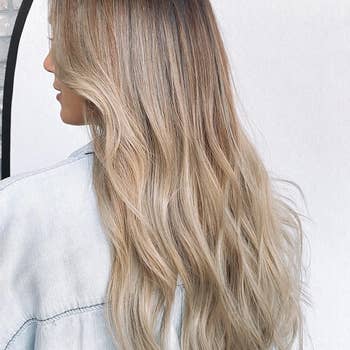 Reviewer with long, wavy hair facing away, wearing a denim jacket.