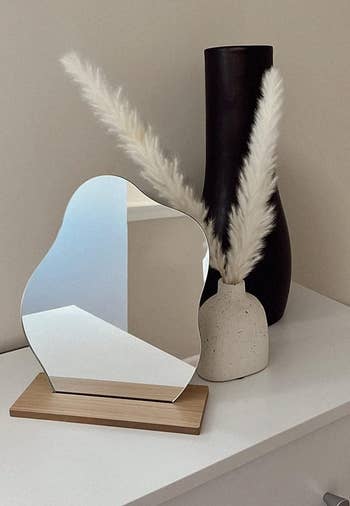 reviewer's mirror next to vases and faux flowers