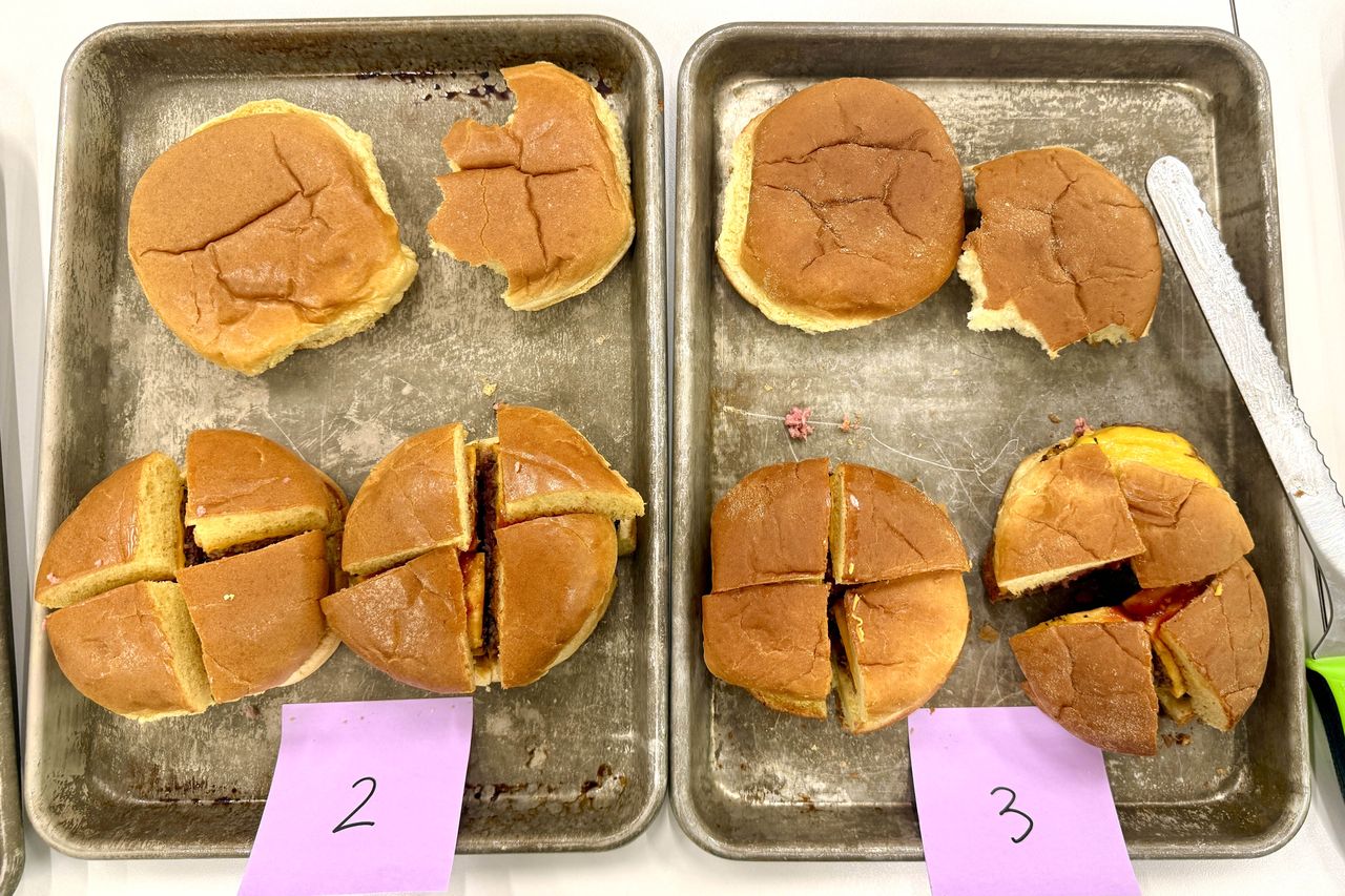 Four burger buns on trays numbered 2 and 3 each bun is sliced into quarters for a taste test setup