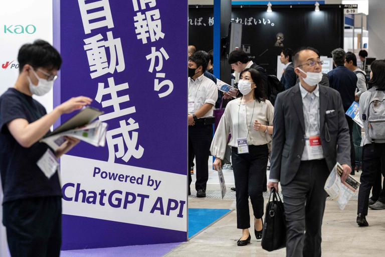 Visitors walk past a sign promoting ChatGPT at an AI Expo in Japan in 2023. Photo: AFP