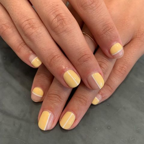 Hands with nails painted using yellow geometric designs