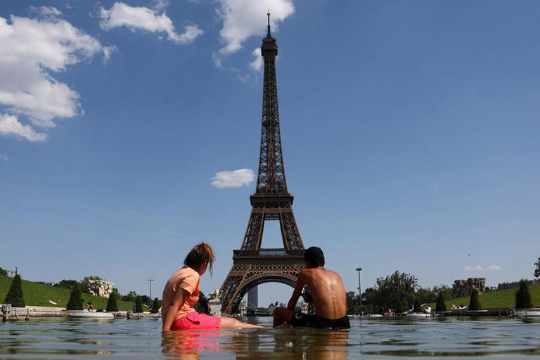 People cool off in the Trocadero Fountain next to the Eiffel Tower in Paris as temperatures rise during a heatwave affecting a large part of France, June 22, 2026. REUTERS/Abdul Saboor
