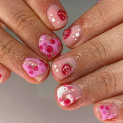 Hands with intricate nail art featuring abstract and heart designs