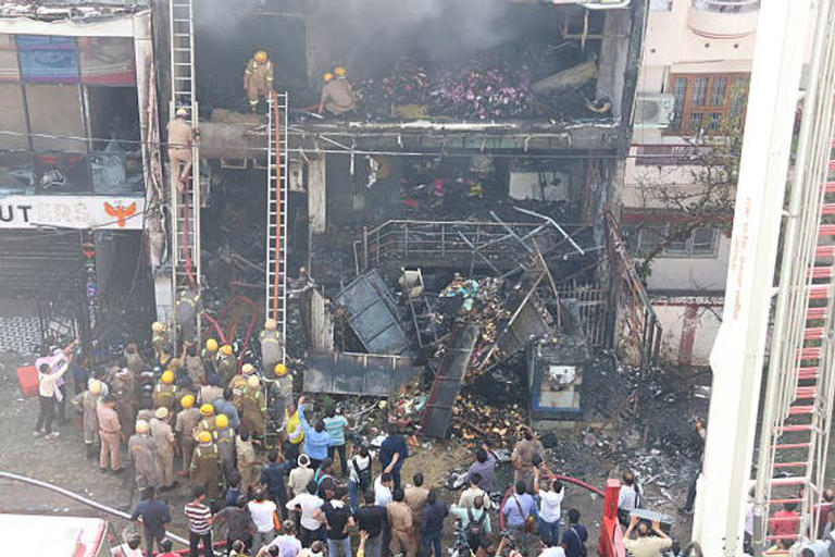 Firefighters and SDRF teams searching the gutted building after a massive fire broke out inside