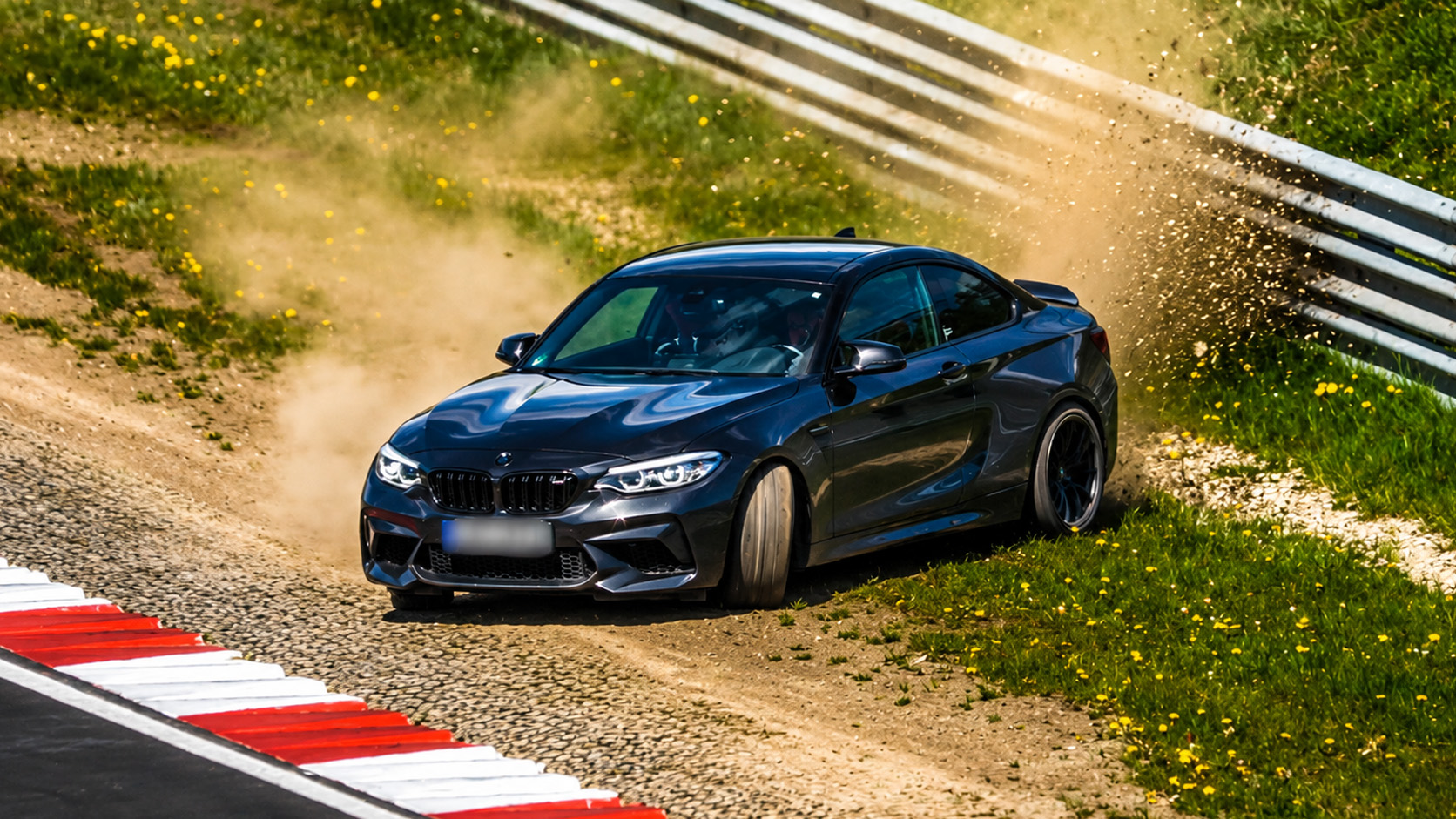BMW M2 loses control and throws dust everywhere near the barrier