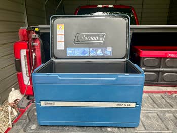 Open Coleman Snap 'N Go cooler on a truck bed with compartments, showing storage space