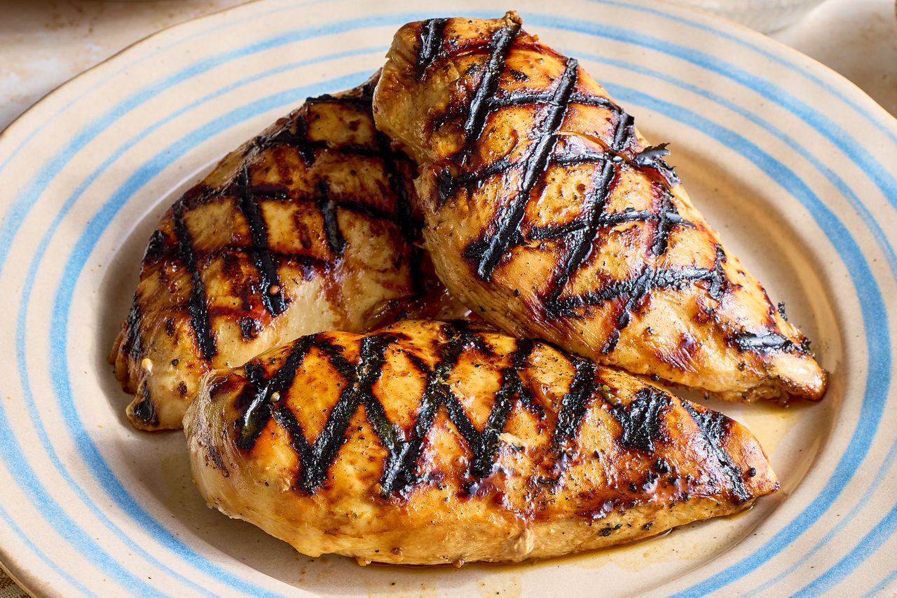 Grilled chicken breasts on a plate with char grill marks
