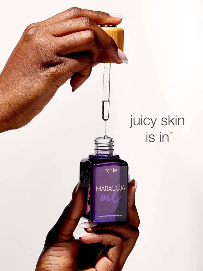 Hands holding Tarte maracuja oil bottle and dropper; text reads
