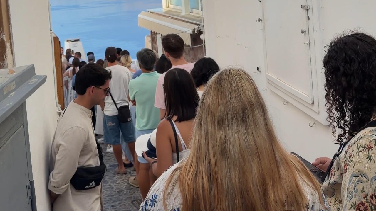 Visitors wait in long queue as tourists take turns for photos in front ...